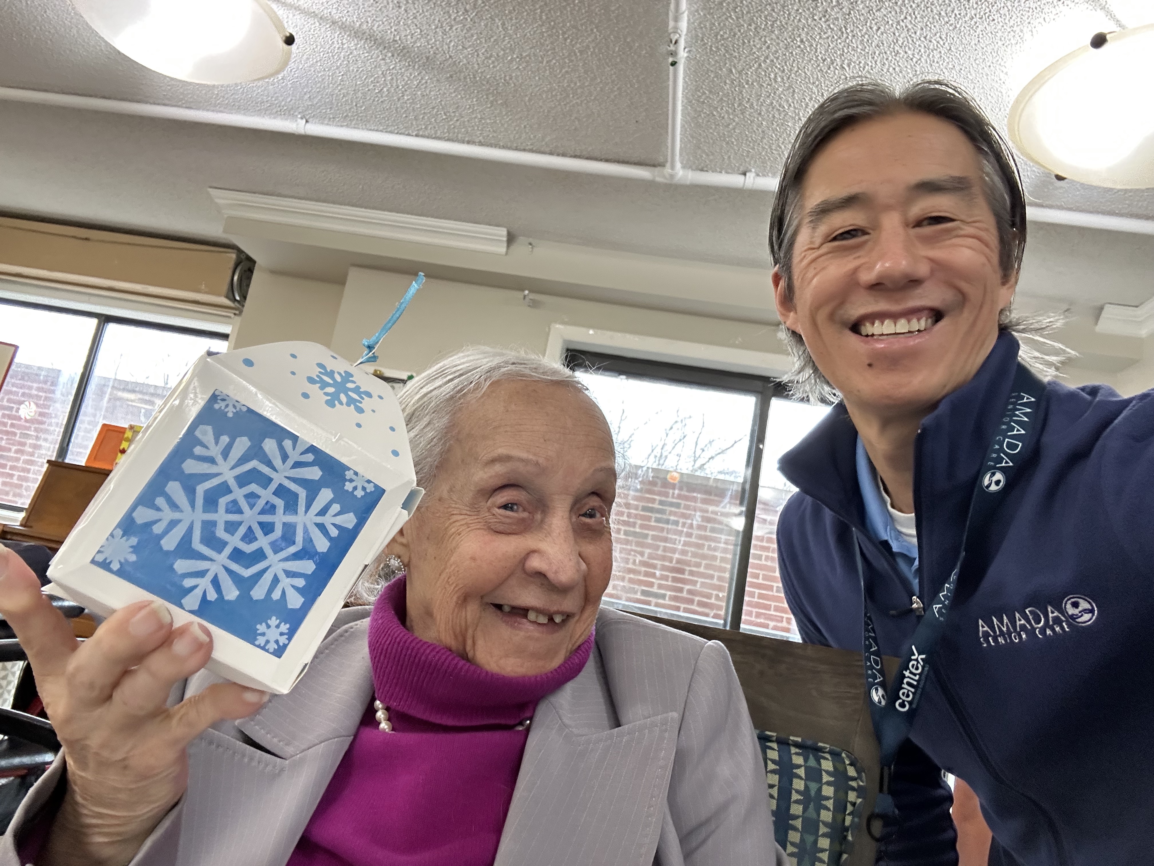 Harbour View Senior Living residents displaying their finished handmade lantern crafts with smiles during the North Bergen arts and crafts program.