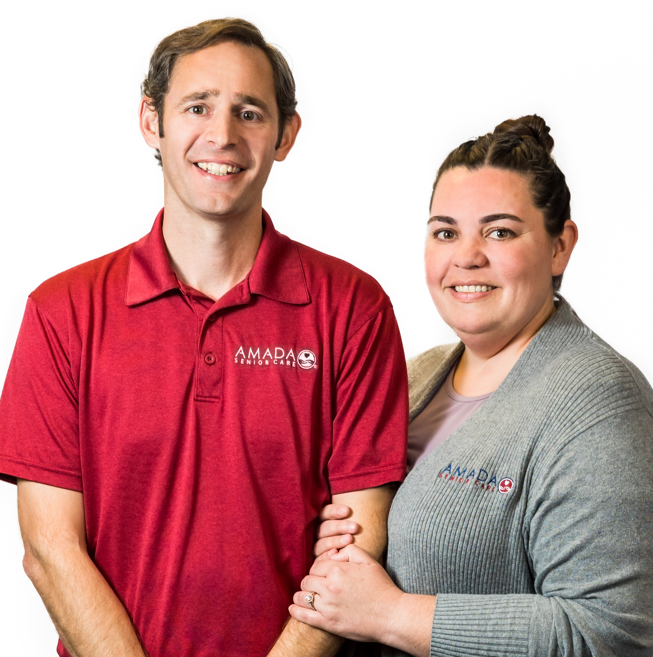 A woman in a gray Amada sweater and a man in a red Amada shirt pose for the camera.