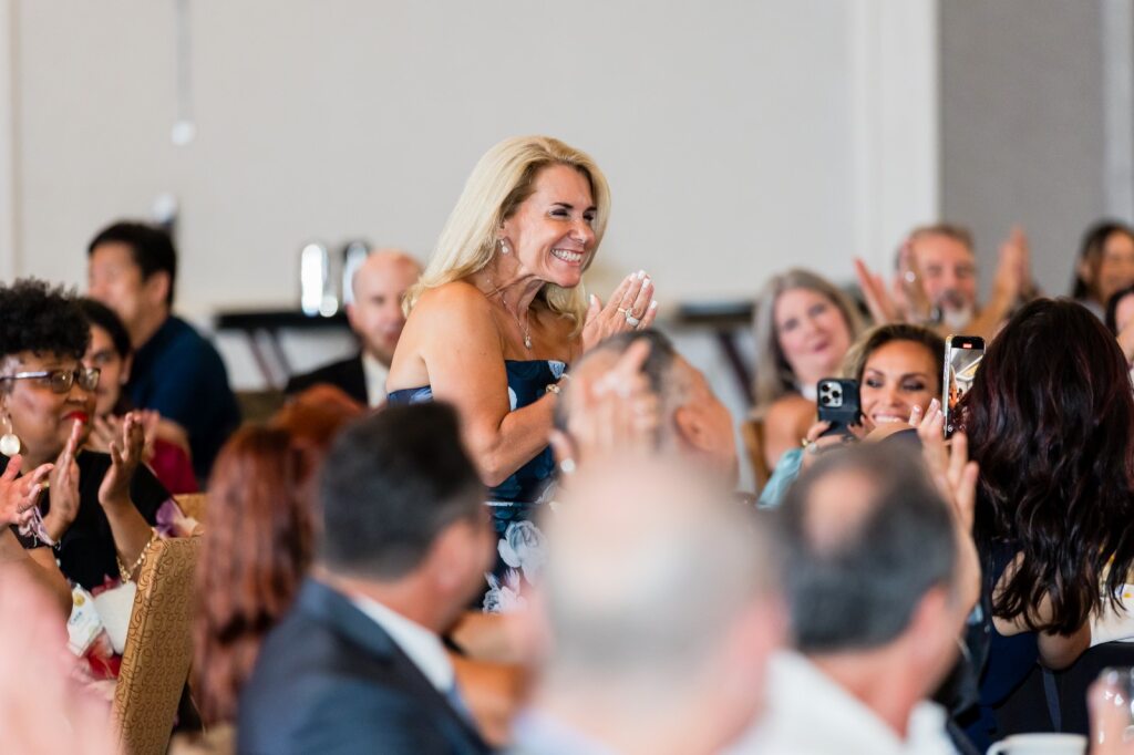 Jennifer Novy is congratulated as she heads toward the awards stage at Amada's annual conference.