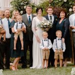 A post-wedding group photo of a large group of men, women, and children of various ages posing for a group photo.