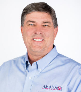 A white guy in a light blue Amada polo smiles for the camera.